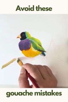 a hand holding a paintbrush and drawing a colorful bird