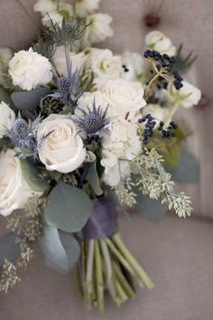 a bouquet of white flowers and greenery on a couch