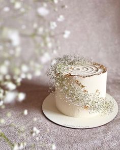 a white cake sitting on top of a table covered in frosting and sprinkles