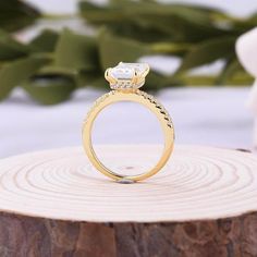 an engagement ring sitting on top of a tree stump