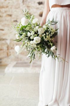 a bride holding a bouquet of white flowers