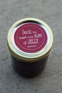 a jar of jelly sitting on the ground with a label that says, deck the toast with blobs of jelly