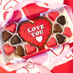 heart shaped chocolates in a valentine's box with the word love you written on it