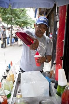 a man is pouring something into a cup