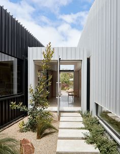 an entry way to a house with white walls and black shutters on the side