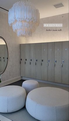 a room with several round stools and a chandelier hanging from the ceiling