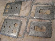 four pieces of metal sitting on top of a marble countertop next to each other