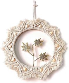 an ornament with two small flowers in the middle and beads around it on a white background