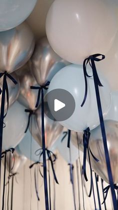 white and blue balloons are tied with black ribbon