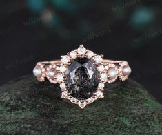 a black and white diamond ring on top of a rock