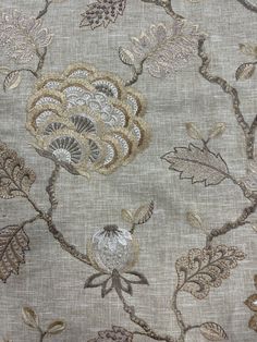 a close up view of the fabric with flowers and leaves on it, in neutral colors