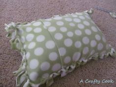 a green and white polka dot pillow on the floor