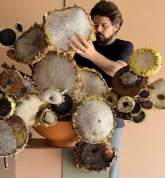 a man standing in front of a bunch of sunflowers that have been cut open