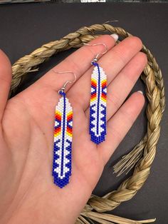 a pair of beaded earrings in the palm of someone's hand