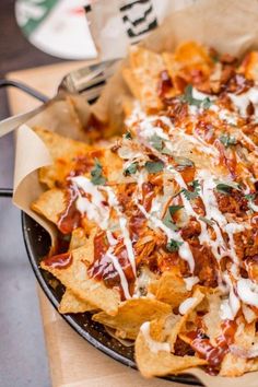 nachos with cheese and sauce in a pan on a table