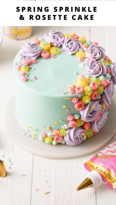 a cake decorated with pastel flowers and sprinkles on a white table