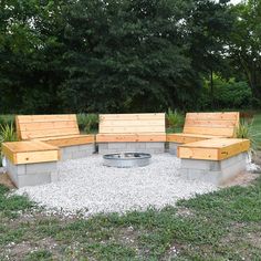 a fire pit surrounded by wooden benches and gravel