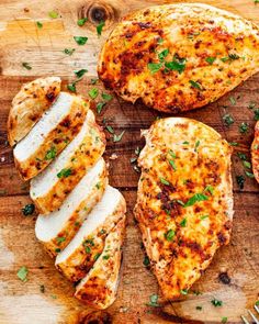 three pieces of chicken on a cutting board next to a knife and some parsley