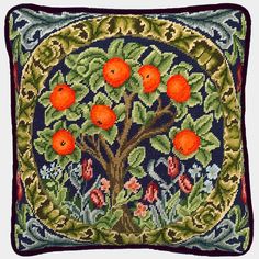 an embroidered pillow with oranges and leaves on the front, in a circular frame