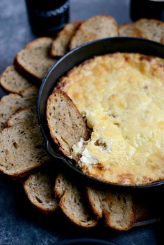 a pan filled with bread and cheese on top of a table