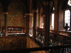 an ornate building with stained glass windows and wrought iron railings on the second floor