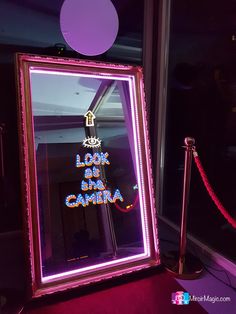 an illuminated mirror with the words look like santa camara on it in front of a red carpet