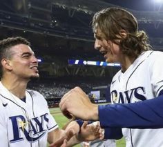 two baseball players are shaking hands on the field