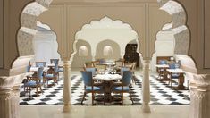 the interior of a restaurant with blue and white tables, chairs, and archways