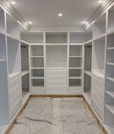 an empty walk in closet with white shelving