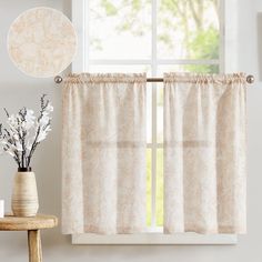 a white window curtain hanging on the side of a wall next to a vase with flowers