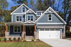 a gray and white house with two garages