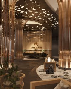 the interior of a hotel lobby decorated in gold and white with wooden columns, rocks and plants