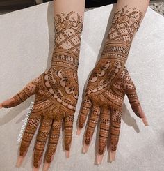 two hands with henna designs on them