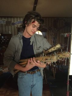 a young man holding an alligator in his hands