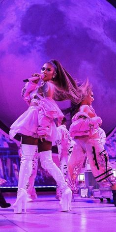 two women in white outfits on stage