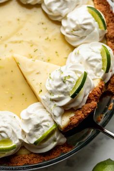 a pie with limes and whipped cream on top is ready to be eaten for dessert