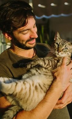 a man holding a cat in his arms