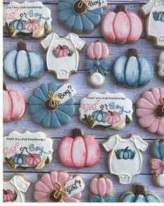 decorated cookies with baby ones and pumpkins are displayed on a wooden surface, along with the names of their babies