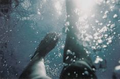 a person standing under water with their feet in the air