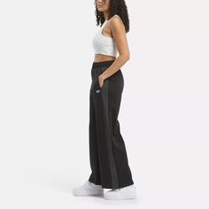 Cheer on your favorite team or just show you're part of Team Reebok in these women's high-rise pants. Inspired by old-school sportswear, these Team Pants update an original with snaps on lower part of the wide legs. The signature sheen of tricot fabric lets you know they're legit. Streetwear Wide Leg Bottoms With Side Stripes, Sporty Full-length Sweatpants With Side Stripes, Sporty Wide Leg Sweatpants For Streetwear, Sporty Full Length Sweatpants With Side Stripes, Athleisure Straight Leg Bottoms With Side Stripes, Sporty Wide-leg Streetwear Bottoms, Sporty Straight Leg Bottoms With Side Stripes, Sporty Wide Leg Gym Bottoms, Athleisure Wide Leg Activewear For Streetwear