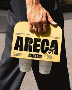 a person holding two cups with the words area bakery on them