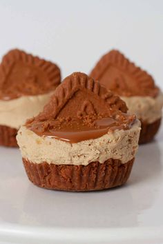 three cupcakes on a white plate with chocolate frosting and peanut butter in the middle