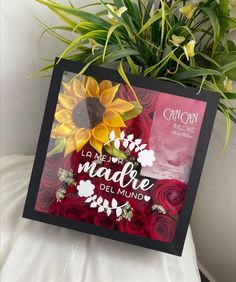 a card with flowers on it sitting next to a potted plant