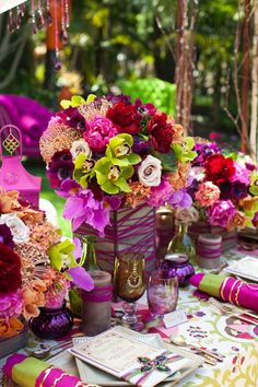 an image of a table setting with flowers and other things on it, including wine glasses