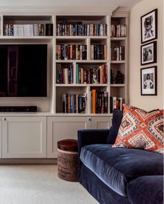 a living room filled with furniture and a flat screen tv mounted to the side of a wall