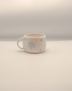 a white cup with blue snowflakes on it