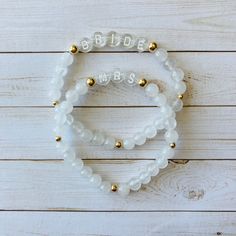 This is the perfect bride to be gift! This natural white jade bracelet is so beautiful with the gold beads + clear letter beads. Each bracelet will arrive individually packaged in an organza bag ready to gift! Bracelets have gold filled beads and won't tarnish. Gold filled is the best + most affordable option after real gold. Please check all selections and spelling prior to check out. Our custom bracelets are made to order so all sales are final. Receipts are never included in your package. If Adjustable White Bracelets For Wedding, Adjustable Charm Bracelet With Round Beads For Wedding, Gold Beaded Charm Bracelet For Wedding, White Pearl Bracelet For Bridesmaid Gift, Gold Wedding Charm Bracelet With Round Beads, White Round Beads Jewelry For Bridesmaid Gift, Personalized Gold Beaded Bracelets For Wedding, Personalized Gold Beaded Bracelet For Wedding, Adjustable White Bracelet For Anniversary