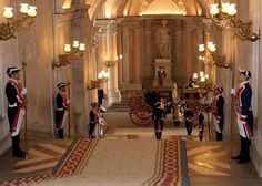 several men in uniform stand at the entrance to a building with an elaborately decorated hallway