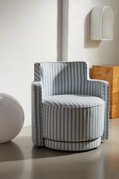 a blue and white striped chair sitting next to a lamp