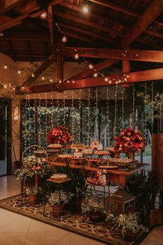 a table with flowers on it and lights hanging from the ceiling in front of it